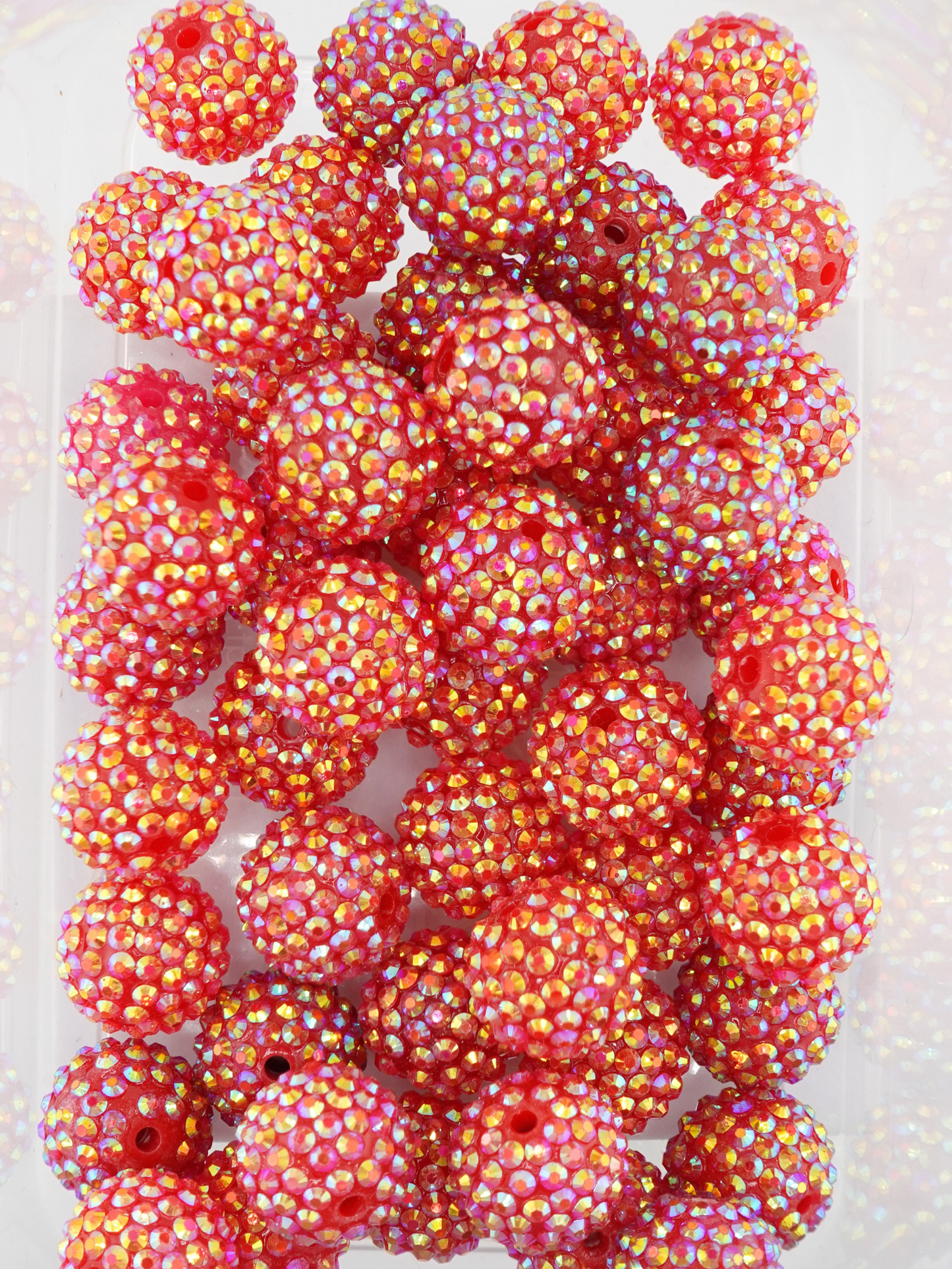 Collection of red beads with shiny aurora borealis finish and rhinestone texture