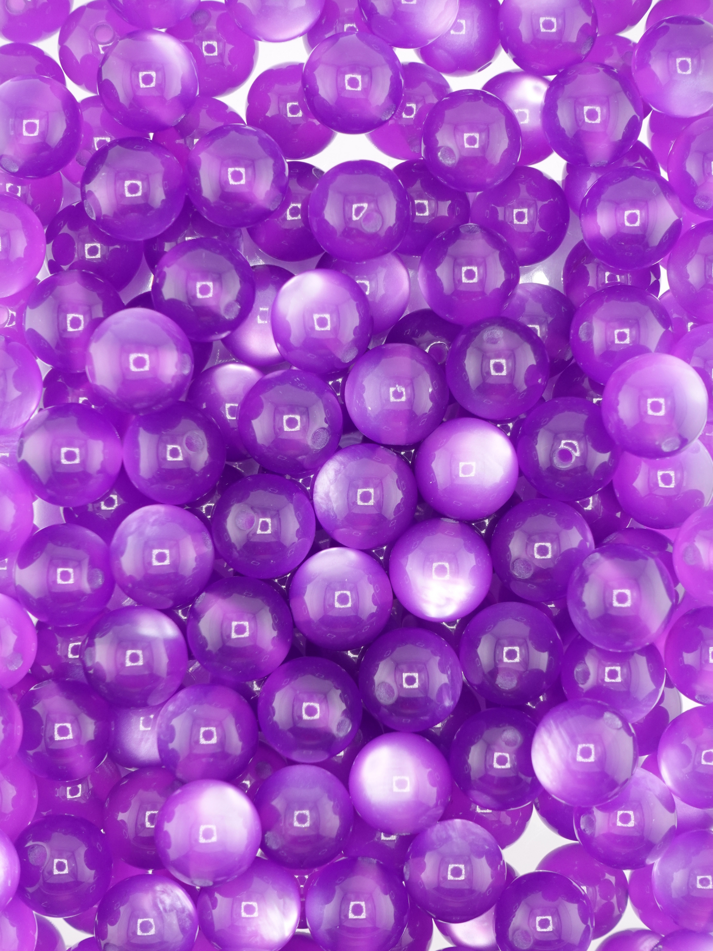 Collection of dark purple colored beads with a cat eye shimmer