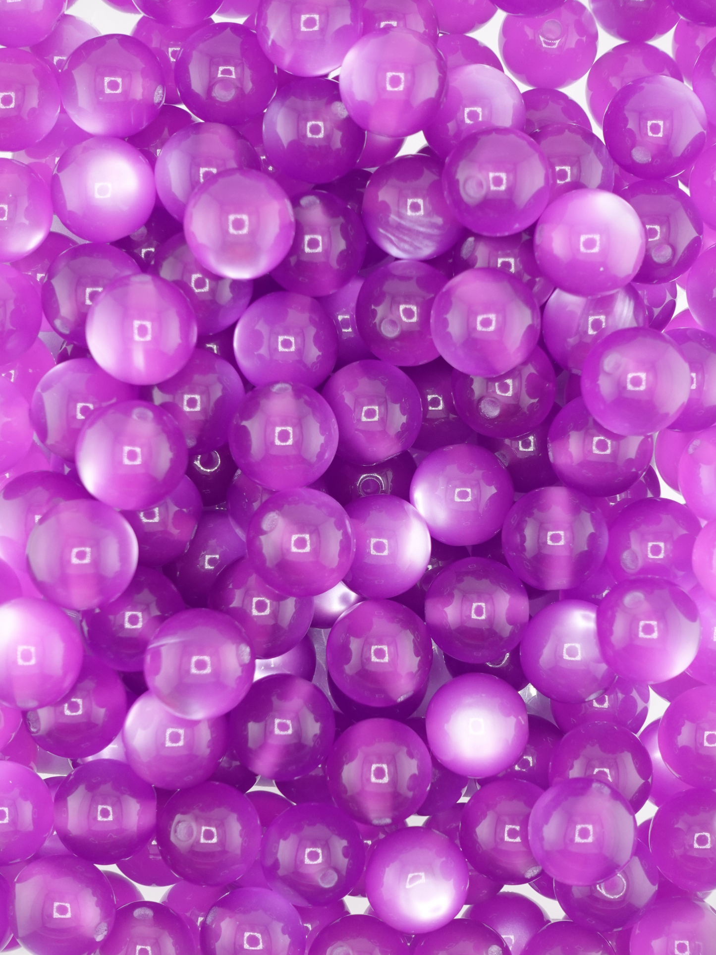 Collection of grape purple colored beads with a cat eye shimmer