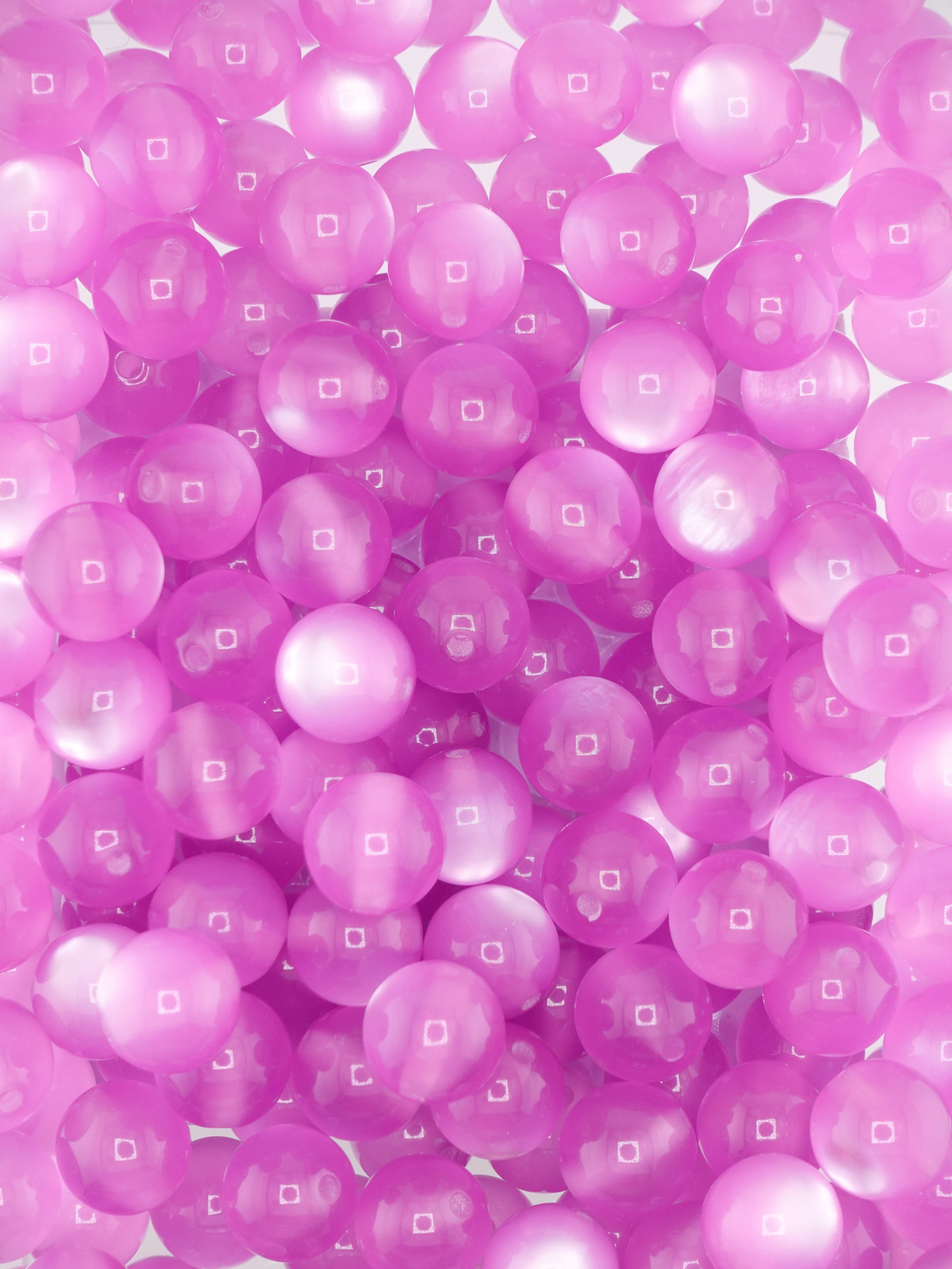 Collection of light purple colored beads with a cat eye shimmer