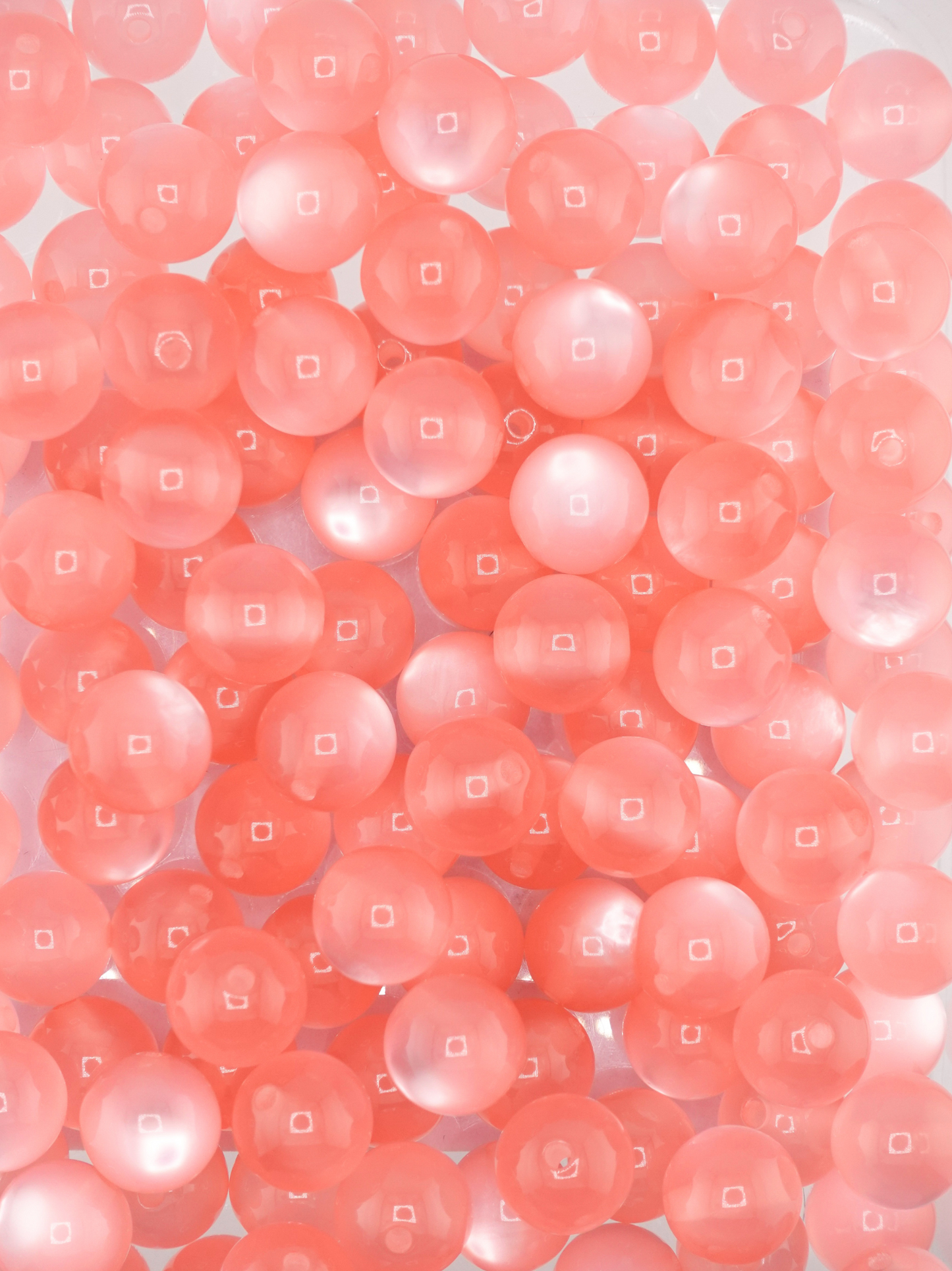 Collection of pink colored beads with a cat eye shimmer