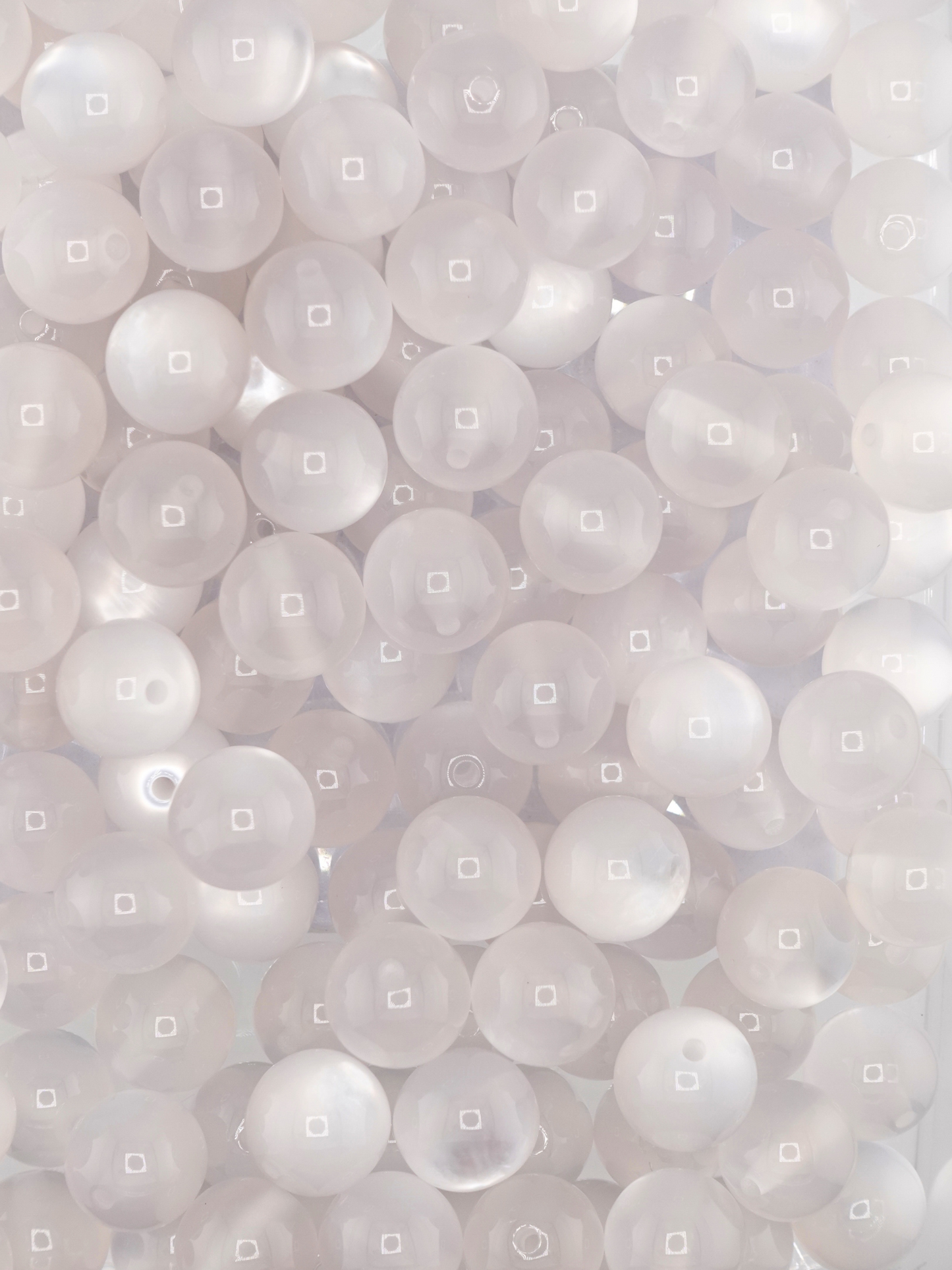 Collection of white colored beads with a cat eye shimmer
