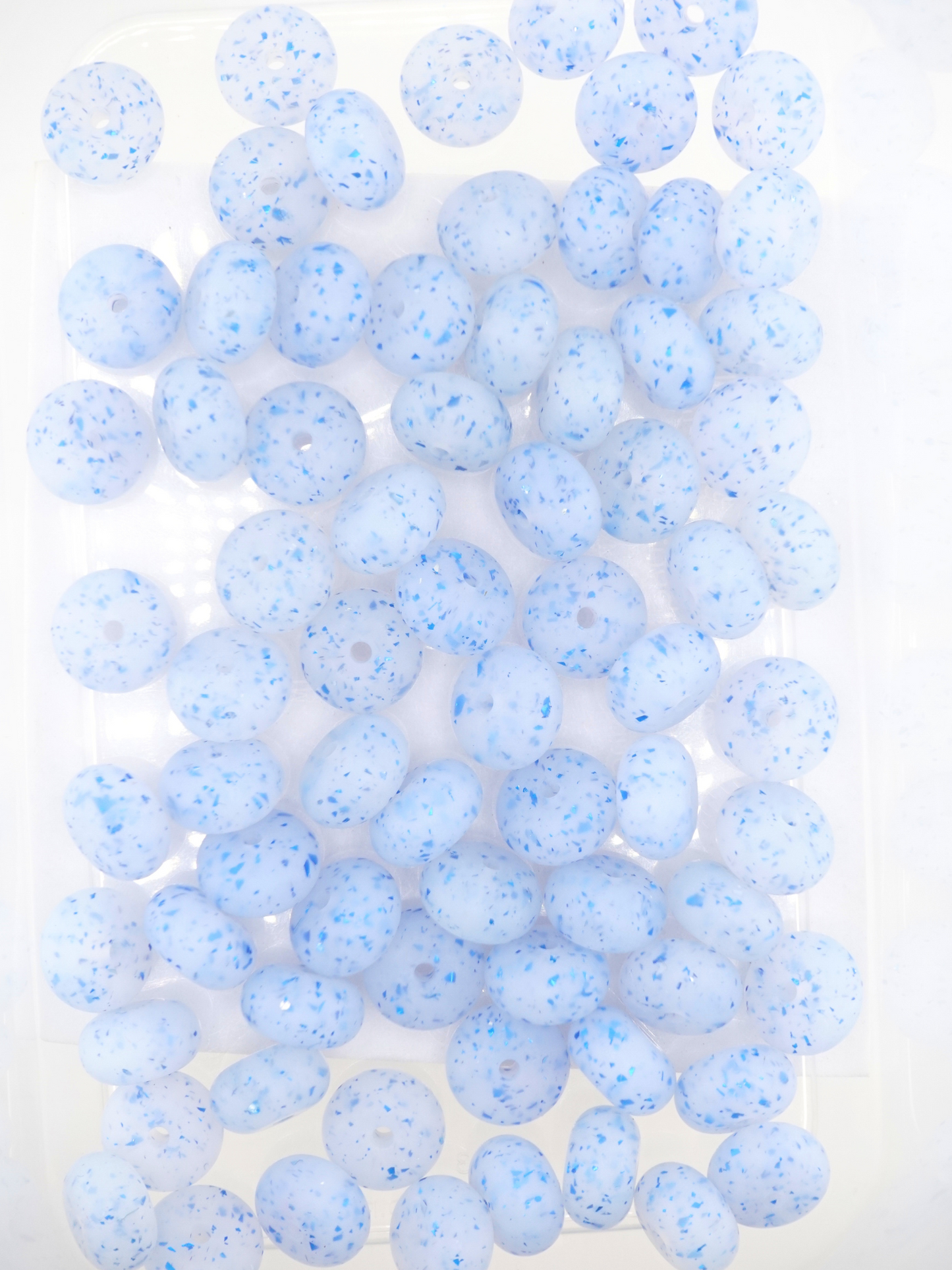 Collection of blue silicone spacers with confetti design and jelly finish