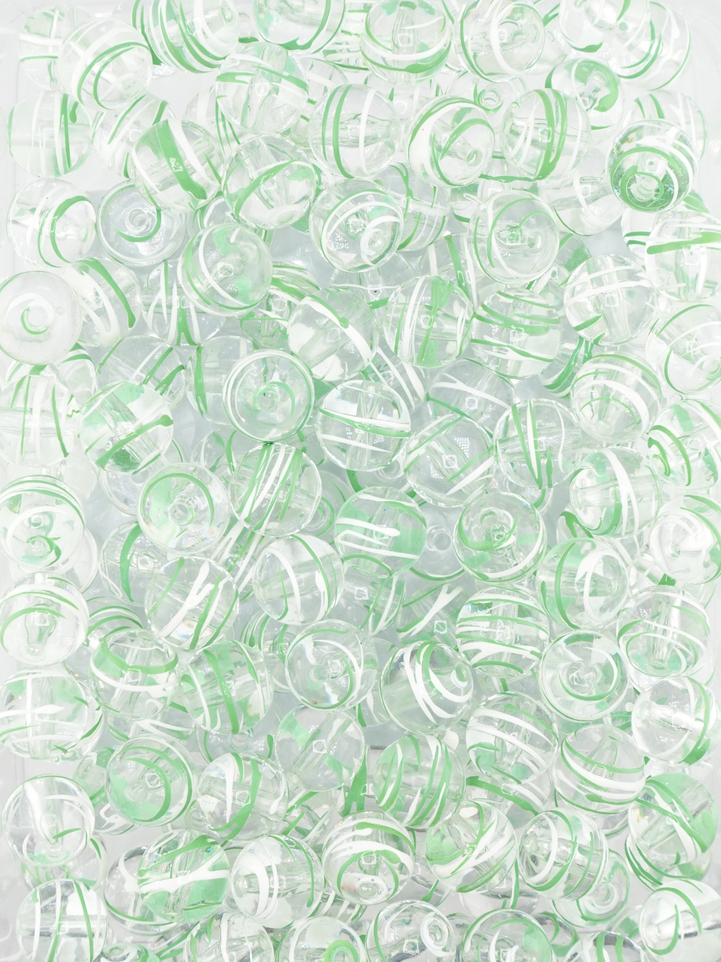 Collection of clear beads with a green and white paint stroke design