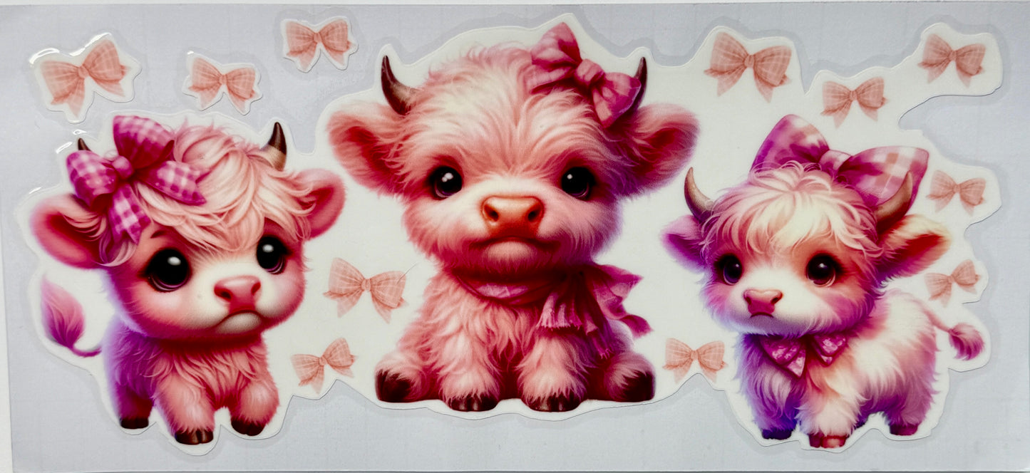 Three cartoon cows with pink hair bows on a light gray background