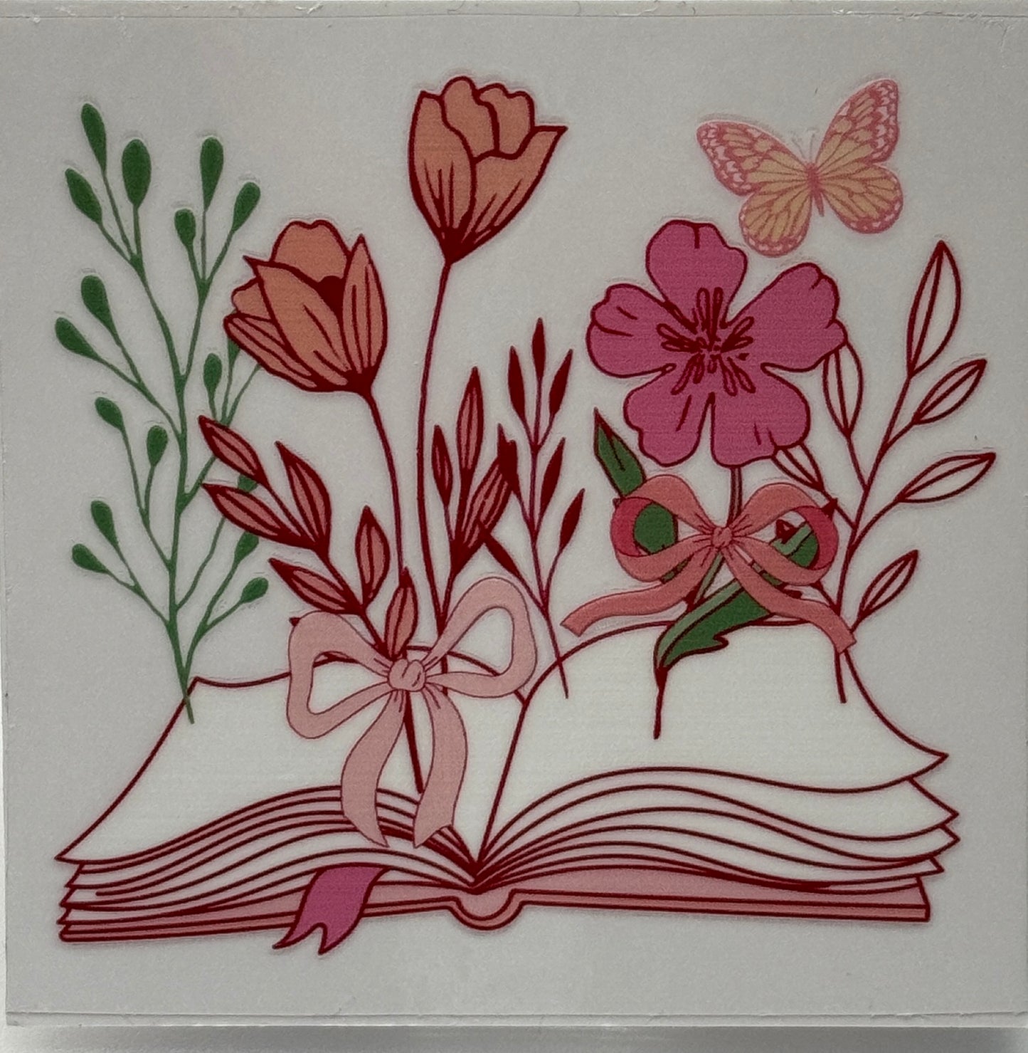 Decorative tile with an open book, flowers, and a butterfly
