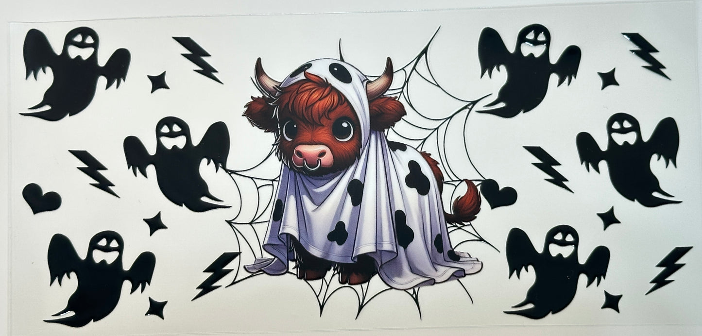 Cute cow in a ghost costume surrounded by black ghost silhouettes