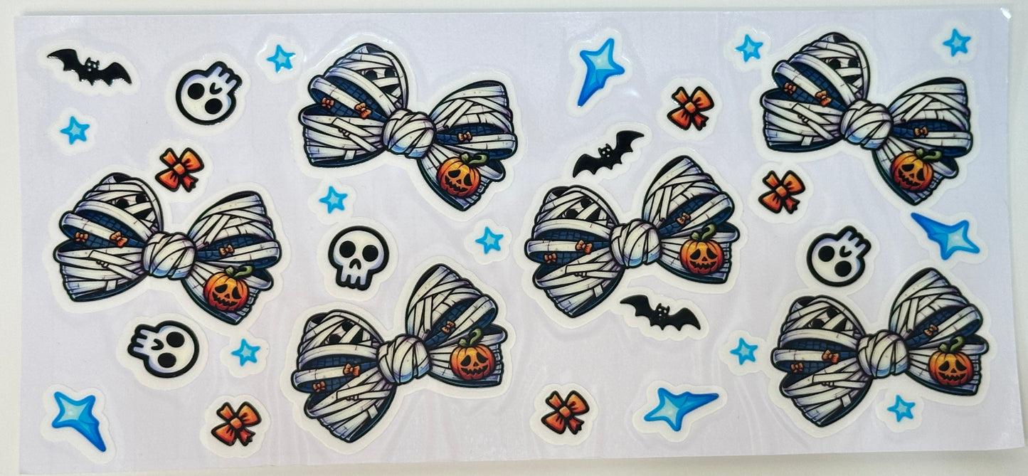 Halloween-themed mummy with bows, pumpkins, bats, and stars