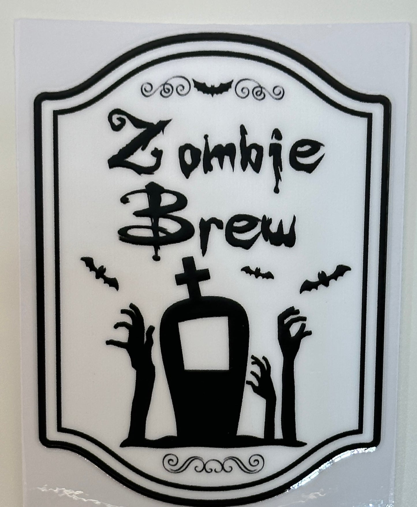 Decorative sign with 'Zombie Brew' text, black hands, and a bottle,