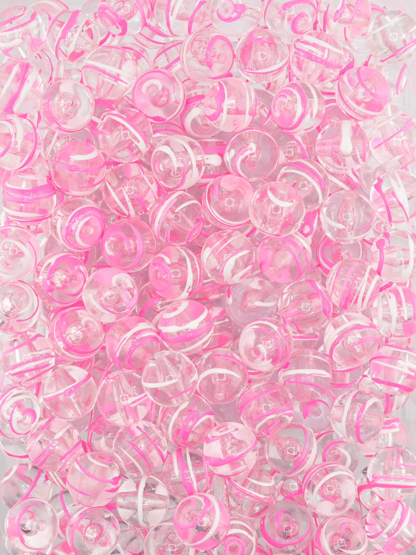 Collection of clear beads with a neon pink and white paint stroke design