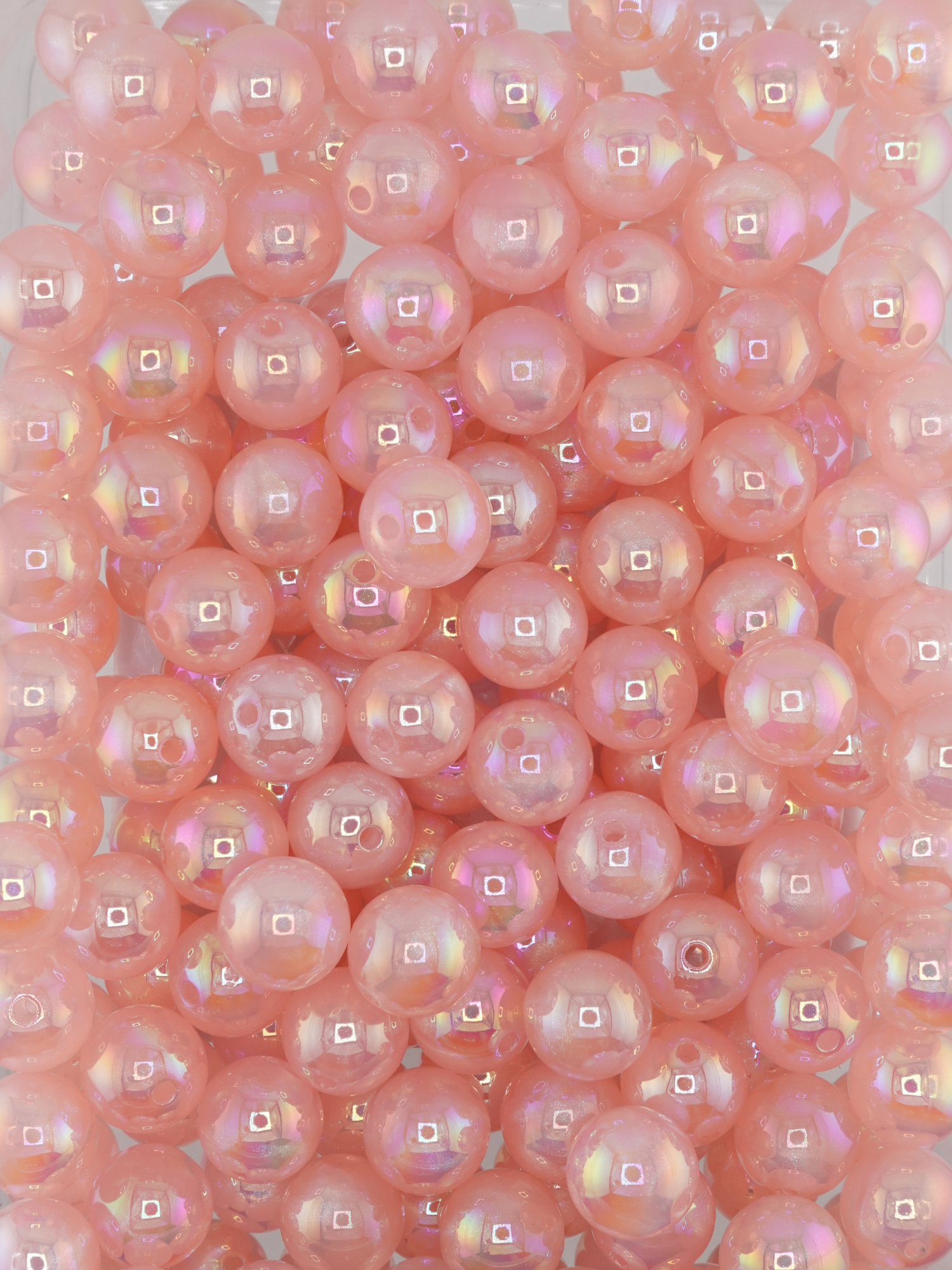 Collection of light pink colored beads with an aurora borealis and galaxy shimmer