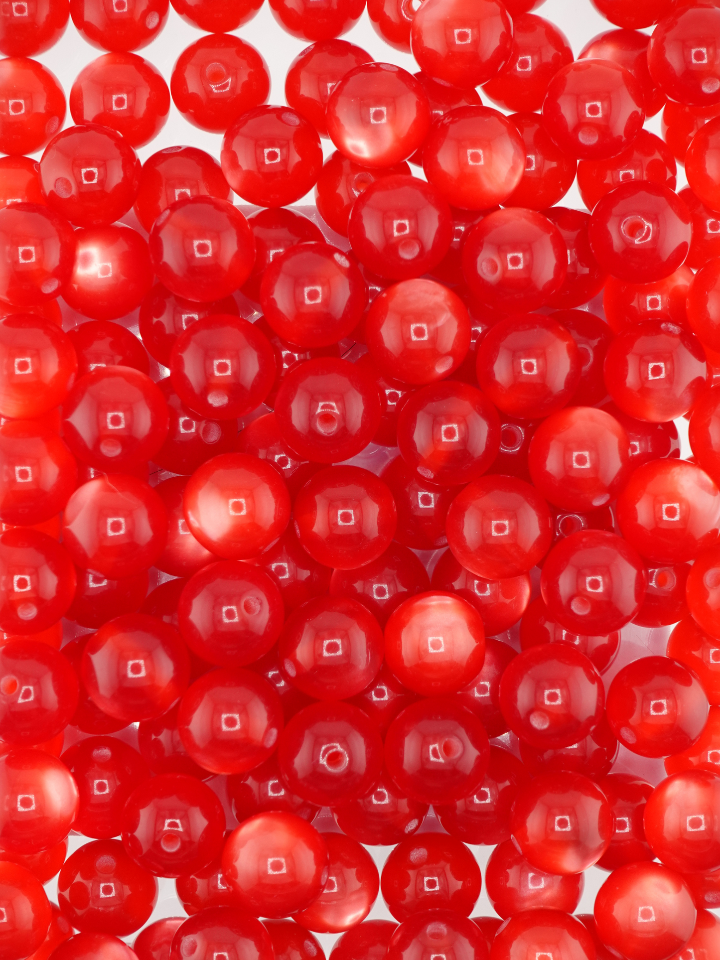 Collection of red colored beads with a cat eye shimmer