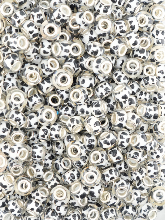Collection of black and white colored spacers with a cow print design