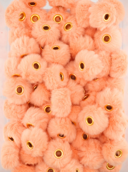 Collection of peach colored fuzzy pom pom spacers