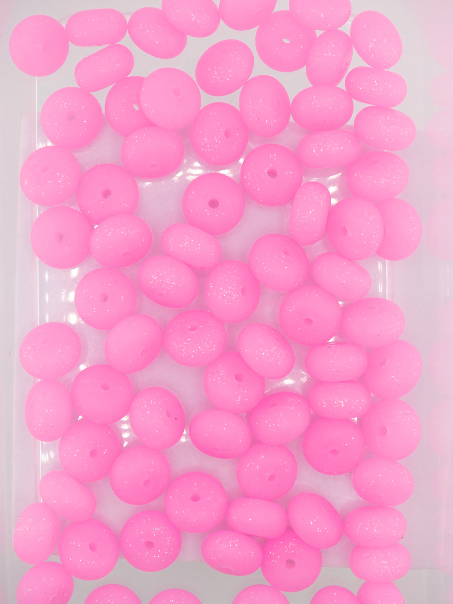 Collection of hot pink colored silicone spacers with glitter