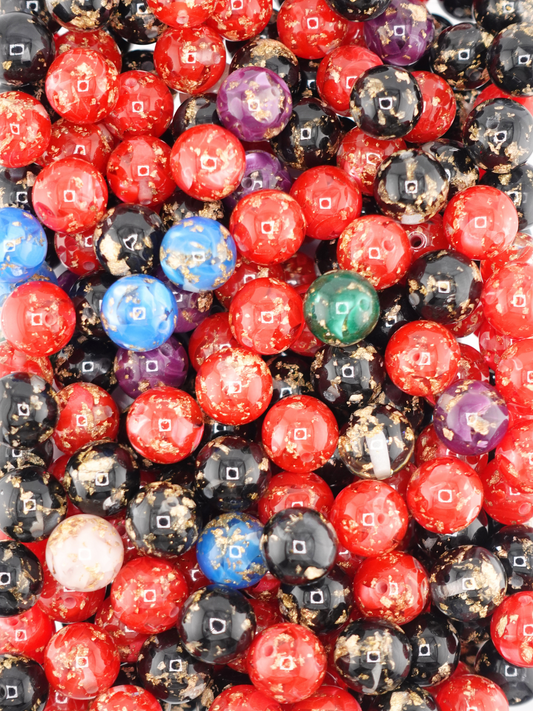 Collection of gold flake beads in a variety of colors; red, black, blue, purple, green