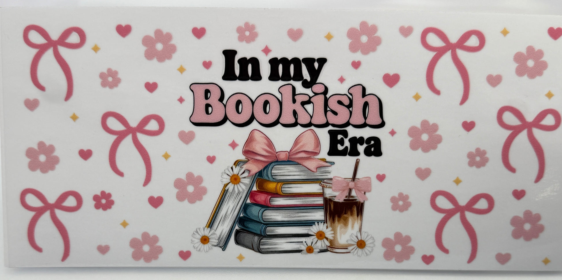 Decorative book cover with 'In my Bookish Era' text, books, and a cup on a floral and bow patterned background.