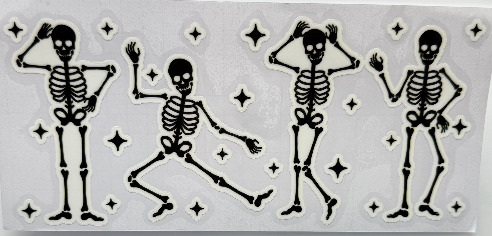 Set of four dancing skeleton figures with star decorations 