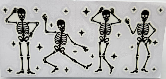 Set of four dancing skeleton figures with star decorations 