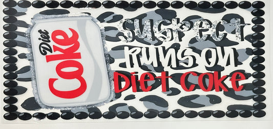 Diet Coke can with text 'Suspect runs on Diet Coke' surrounded by black and white pattern