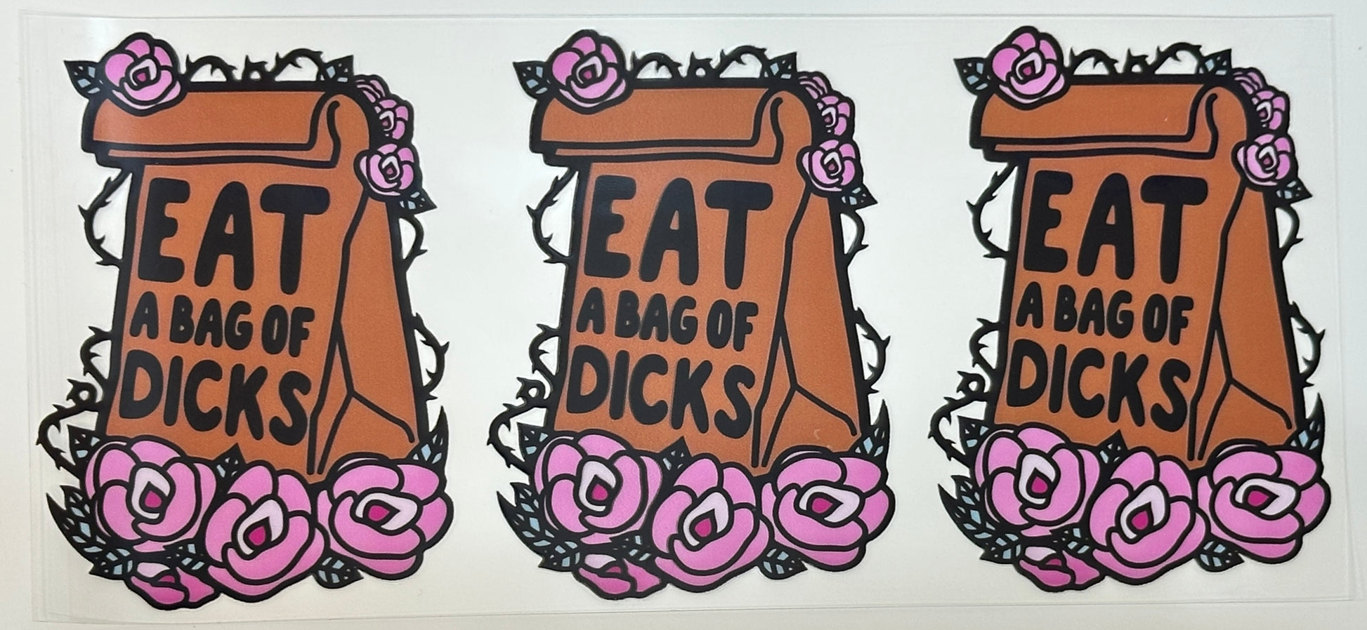 Three identical stickers with text 'EAT A BAG OF D!CKS' surrounded by floral designs 