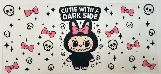Cartoon character in a black outfit with pink bows and text 'Cutie with a Dark Side' on a patterned background.