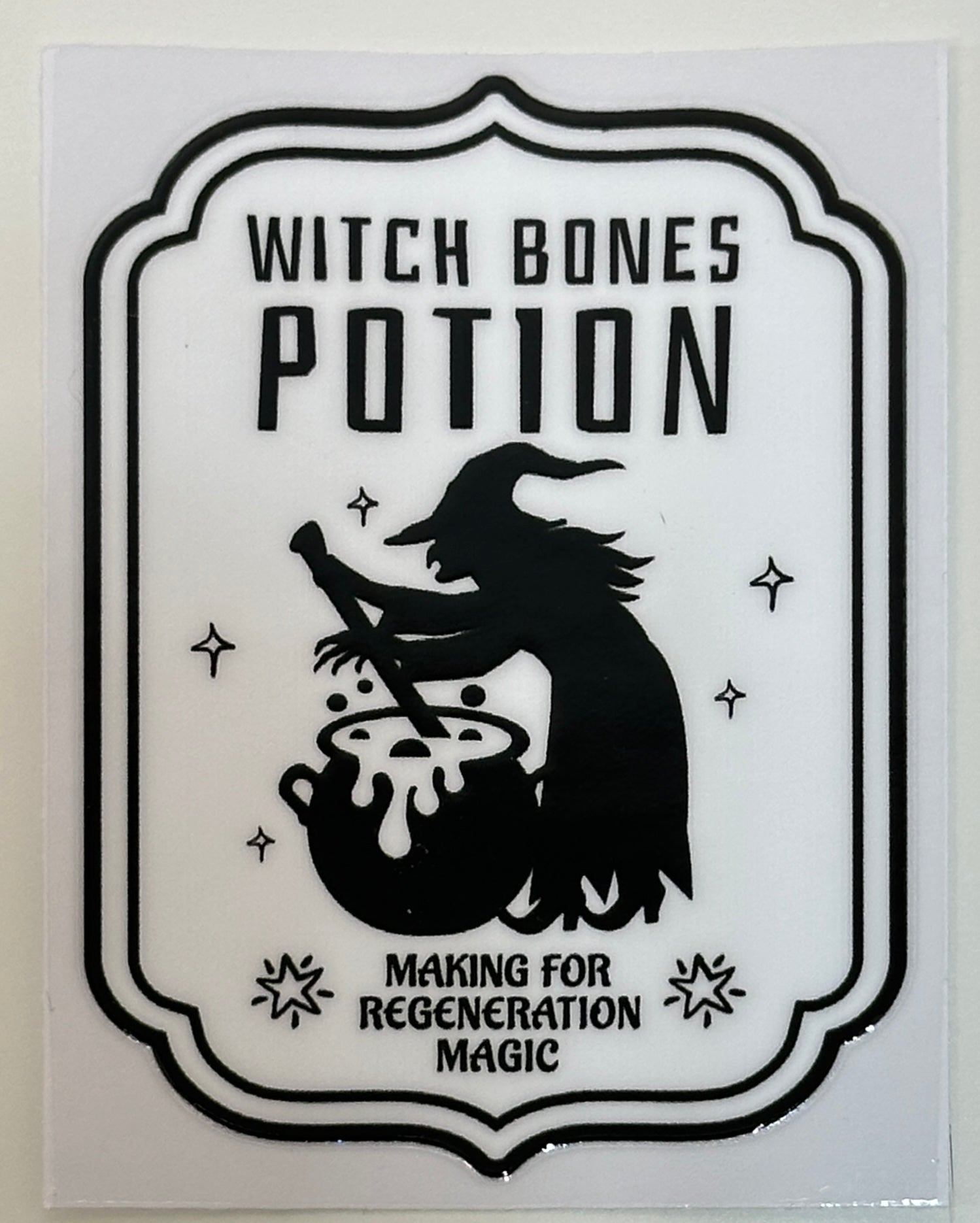 Sticker with 'Witch Bones Potion' design featuring a witch and cauldron 