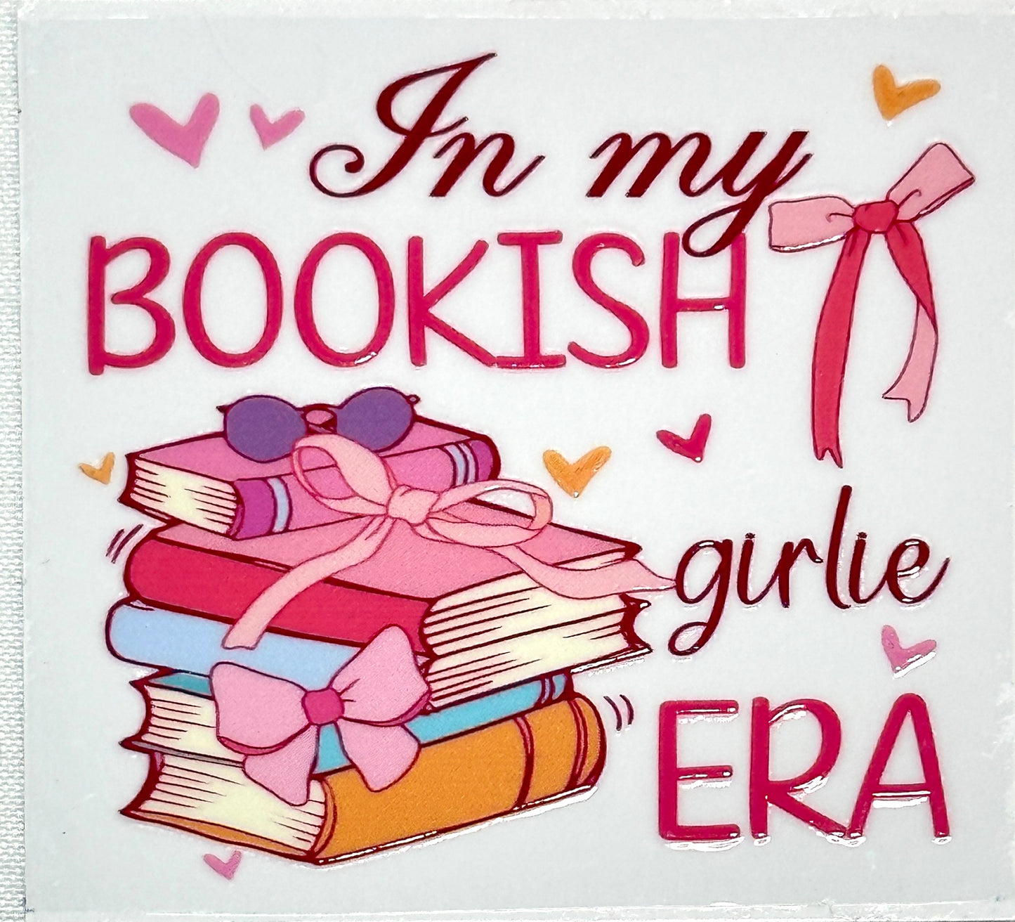 Cartoon books with bows and sunglasses on a white background with text 'In my bookish girlie era'.