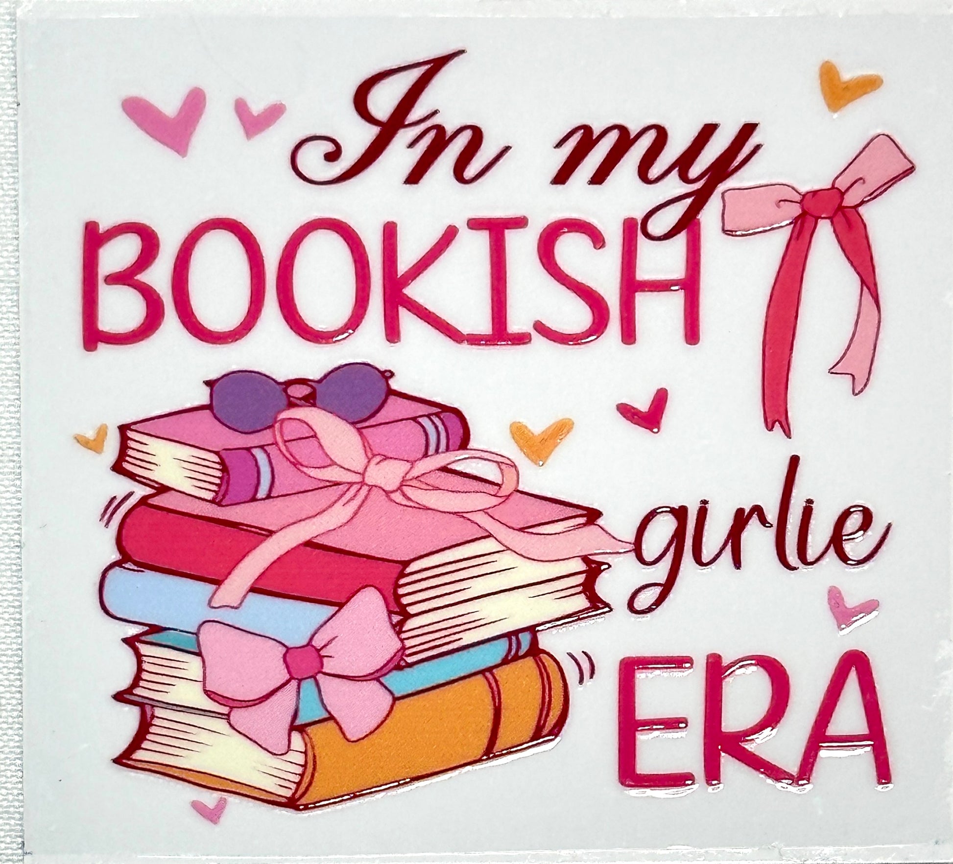 Cartoon books with bows and sunglasses on a white background with text 'In my bookish girlie era'.