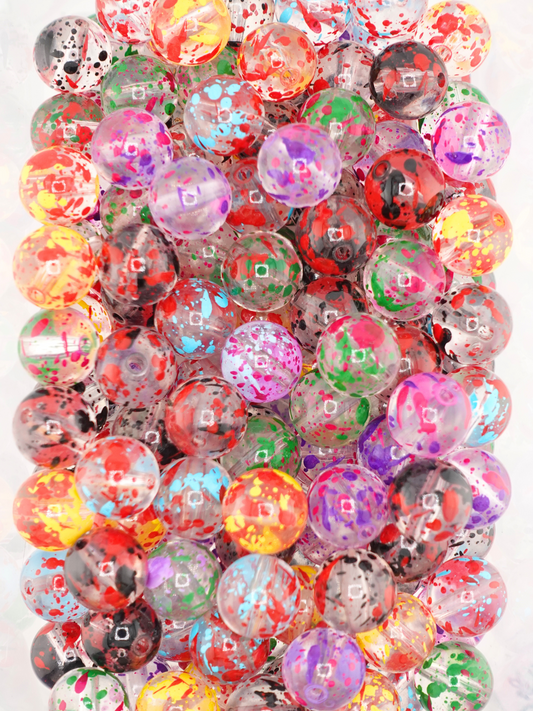 Collection of clear beads with different colored paint splatter designs