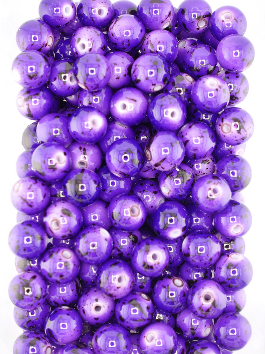 Collection of purple beads featuring black paint splatters
