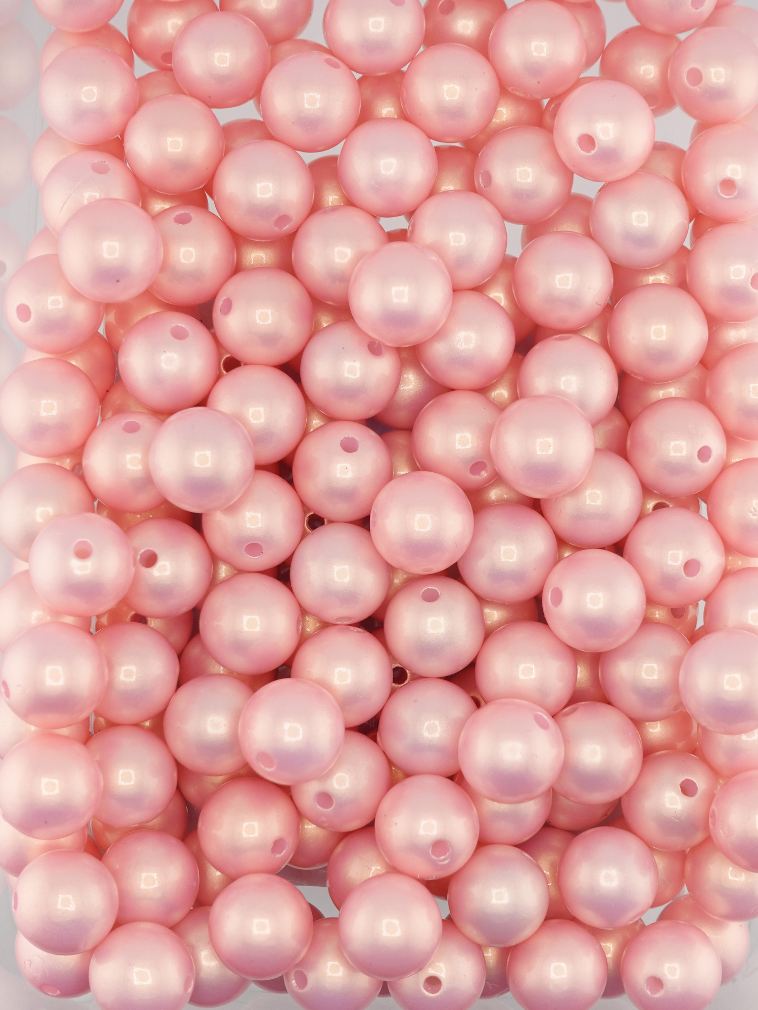 Collection of light pink colored beads with a pearl shimmer finish