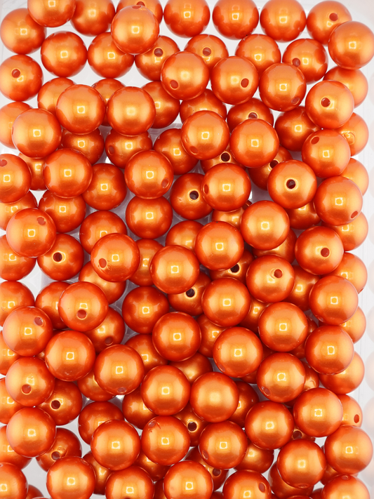 Collection of orange colored beads with a pearl shimmer finish