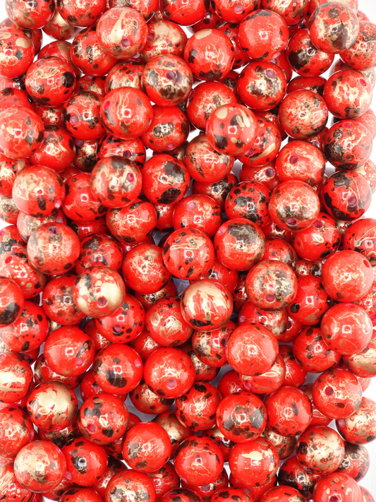 Collection of red beads with a pearl finish and paint splatter design