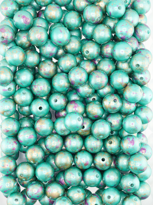 Collection of teal beads with a pearl finish and paint splatter design