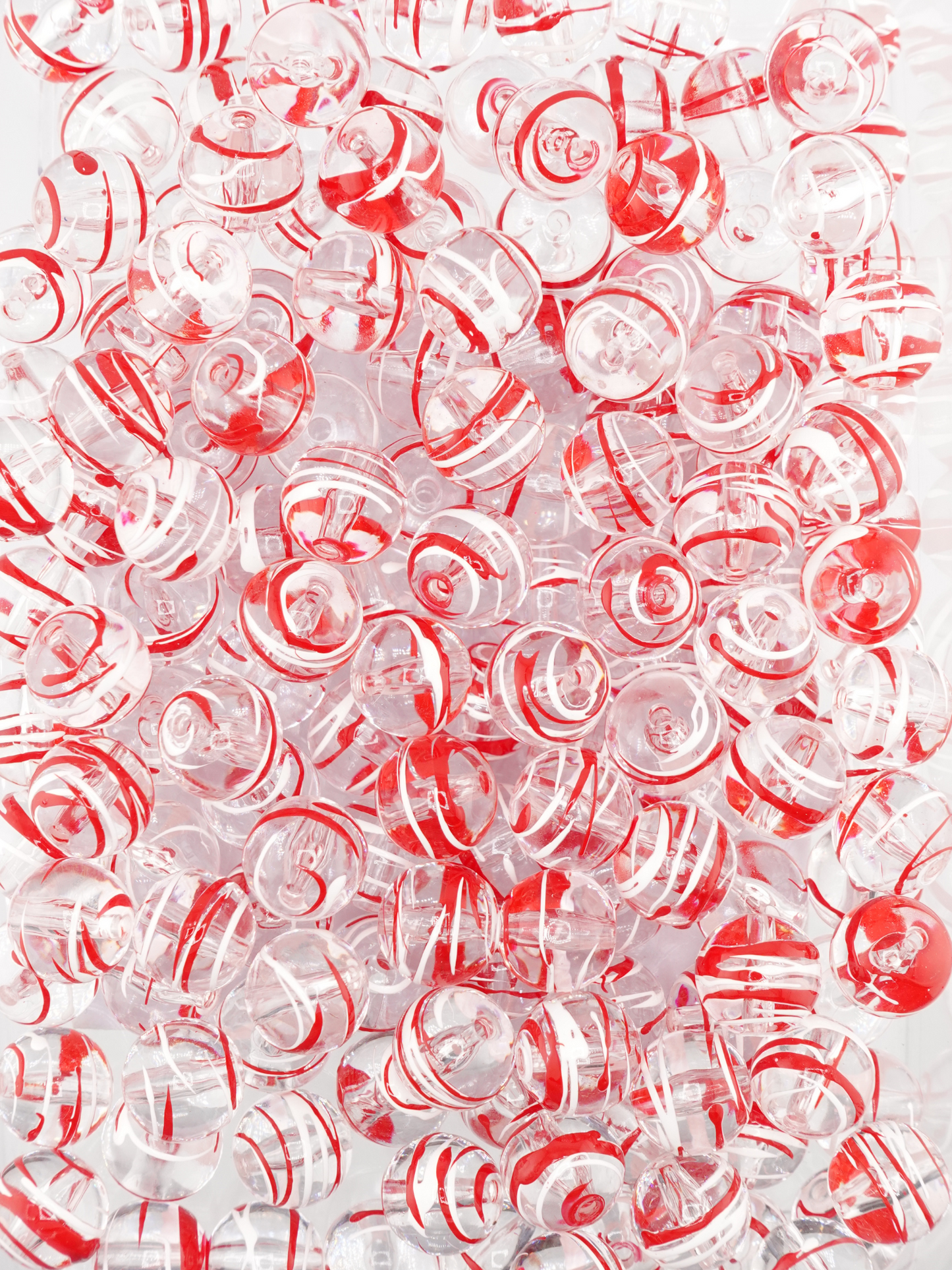 Collection of clear beads with a red and white paint stroke design