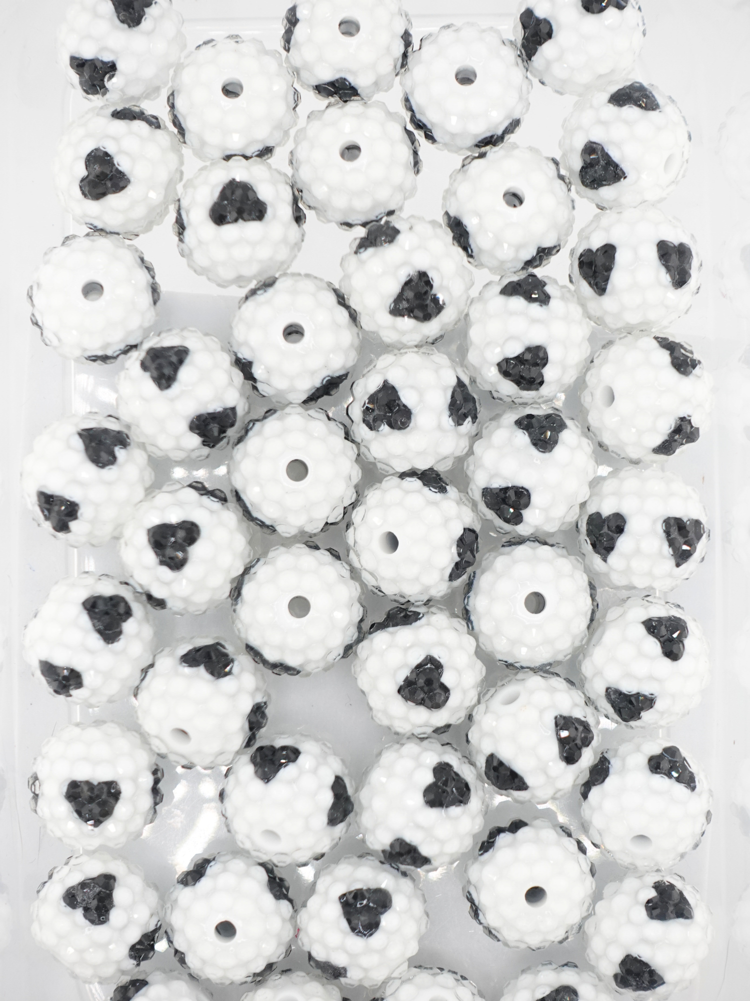 Collection of white rhinestone beads with a black hearts design