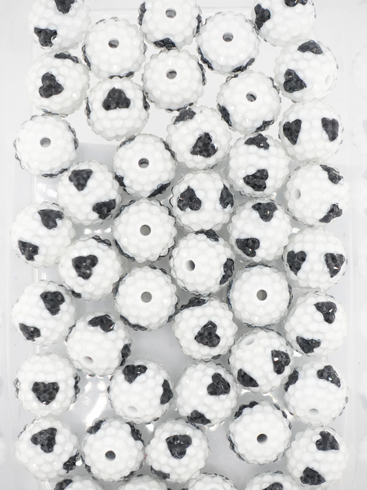 Collection of white rhinestone beads with a black hearts design