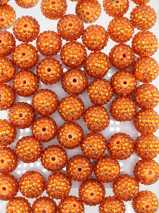 Collection of orange colored beads with rhinestone texture