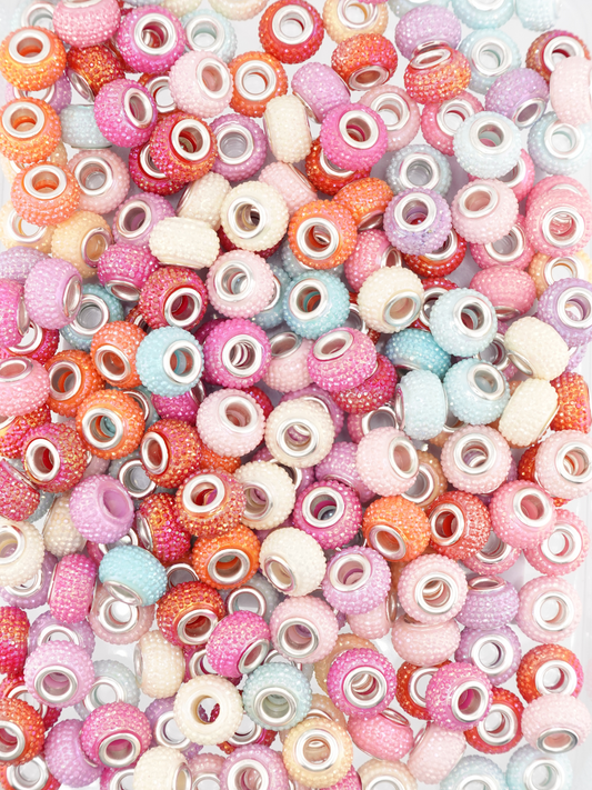 Collection of different colored blue and pink spacers with a textured studded design