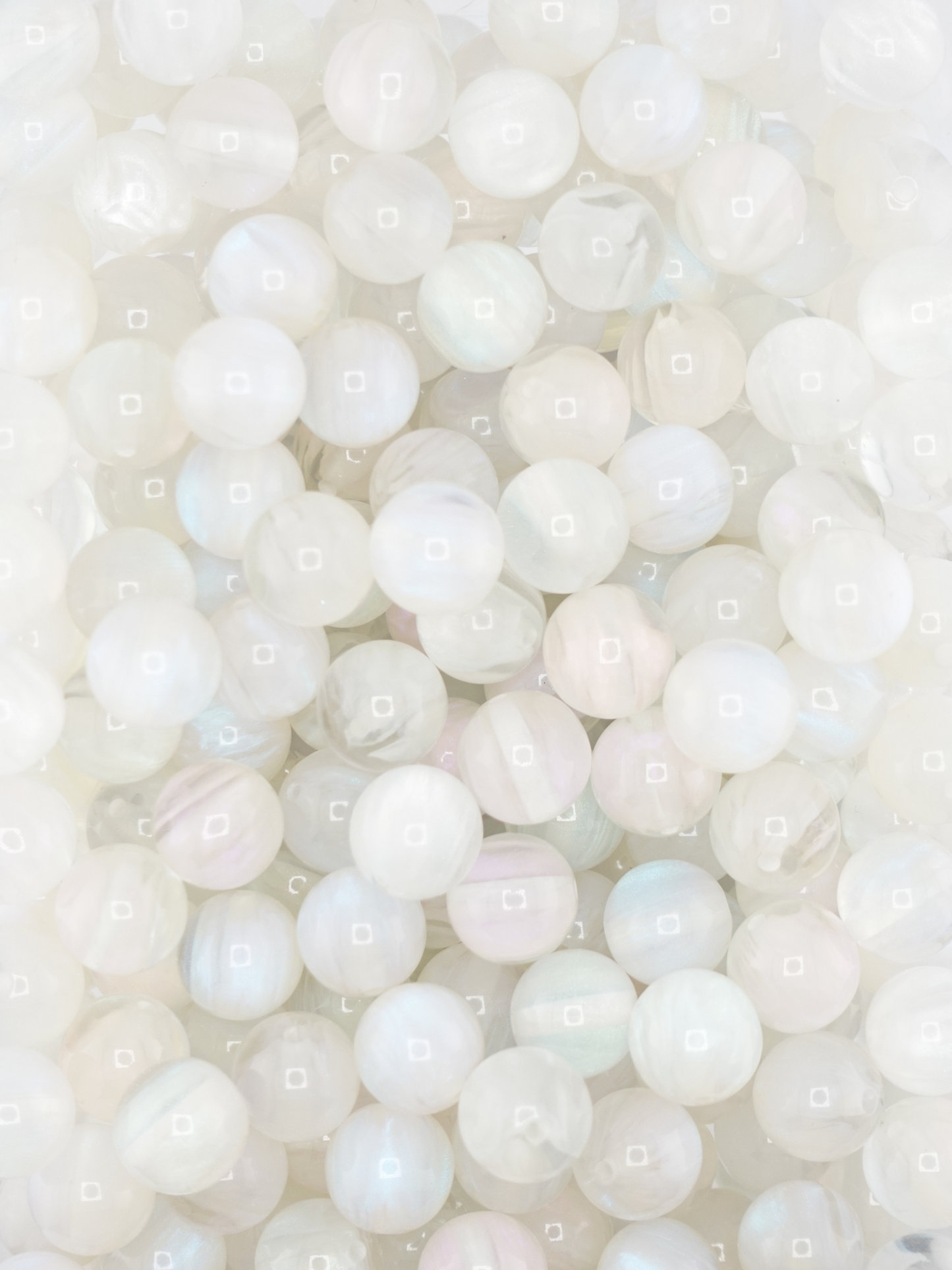 Collection of volcano beads in the colors white, light pink, and light blue. Pastel colors