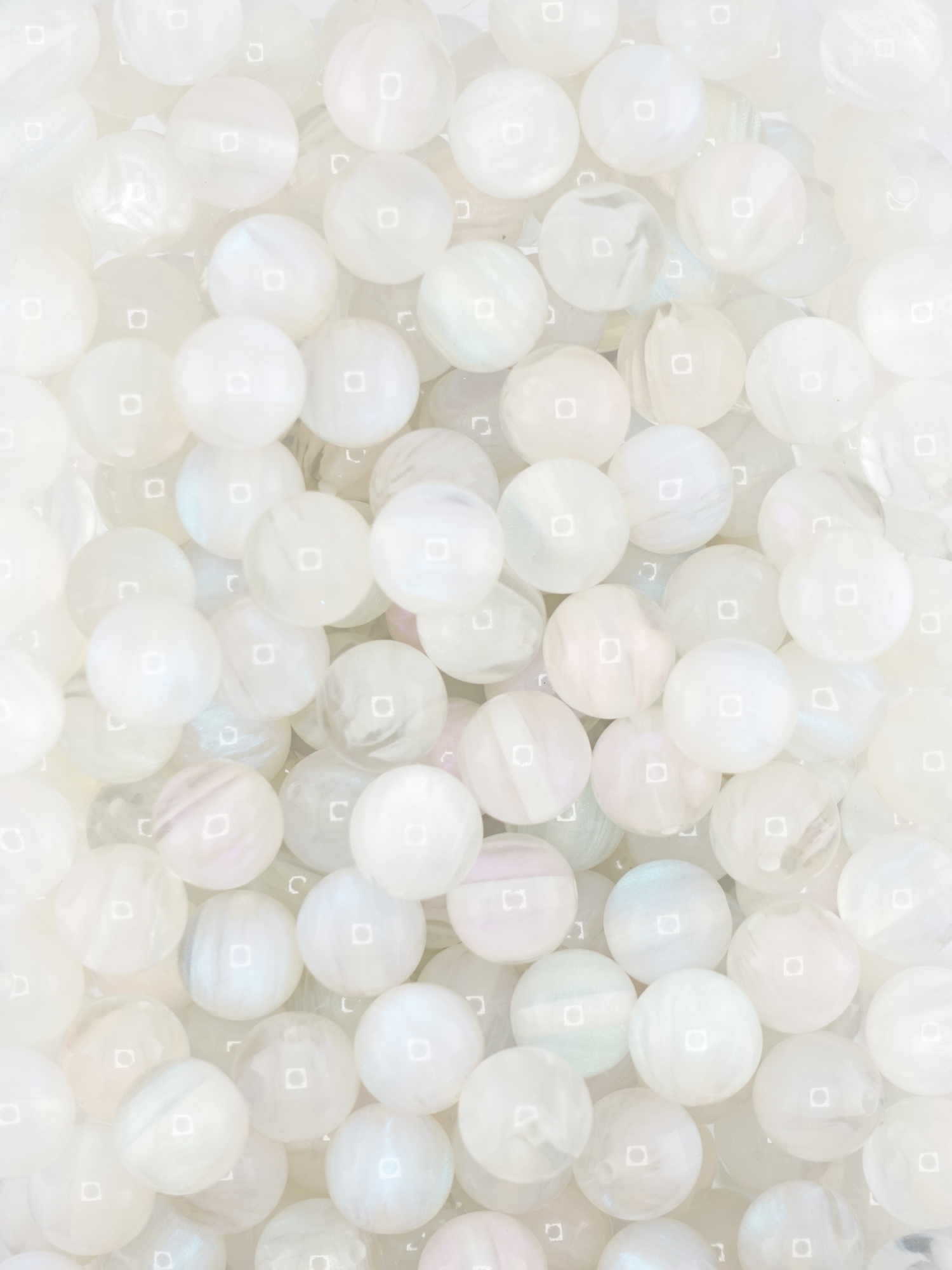 Collection of volcano beads in the colors white, light pink, and light blue. Pastel colors